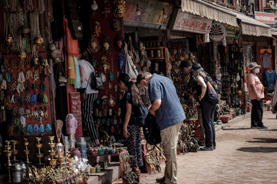 Families and students browsing handmade crafts and local goods in a friendly market aisle.