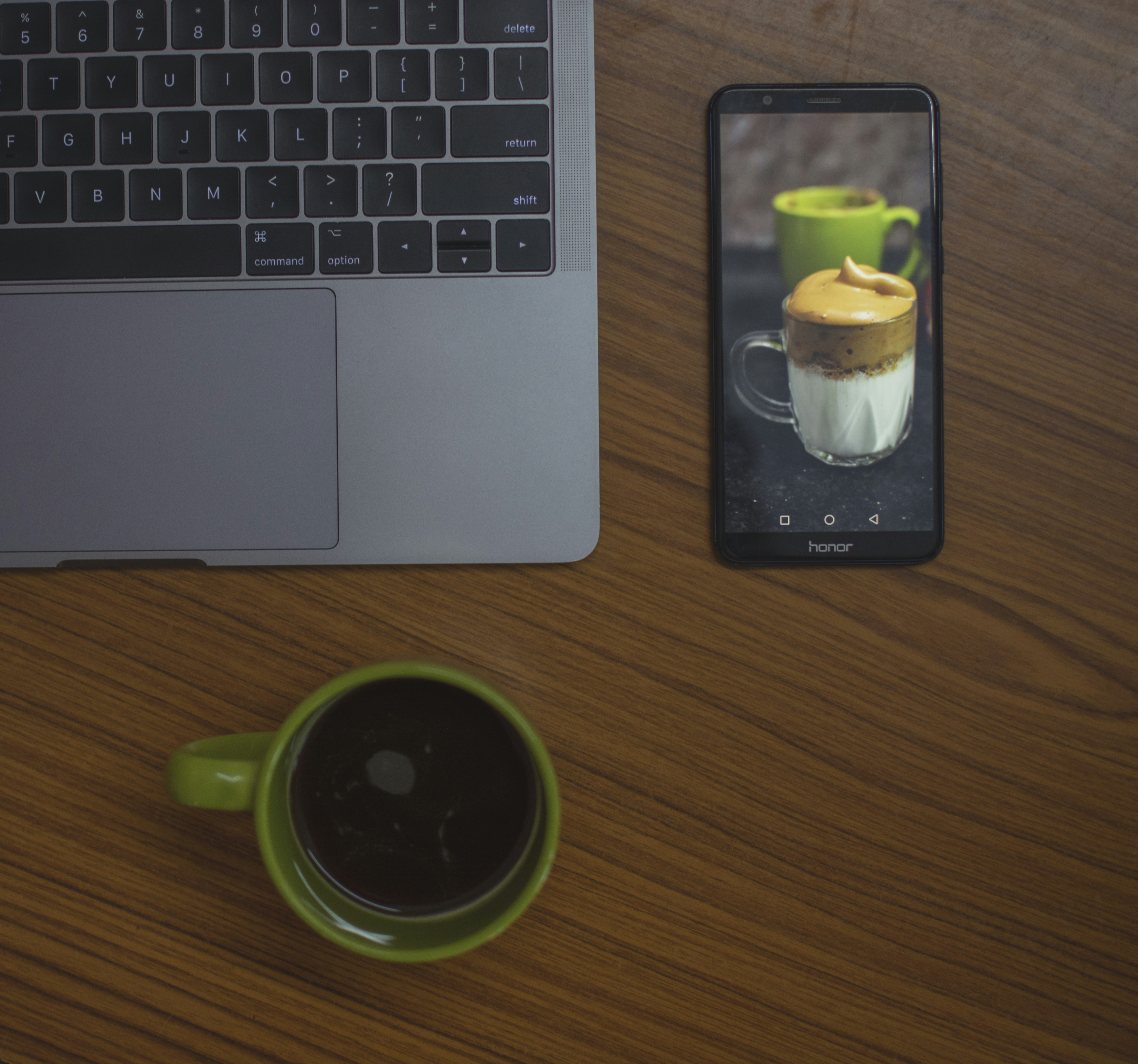 Mug Keramik Hijau di samping MacBook Pro