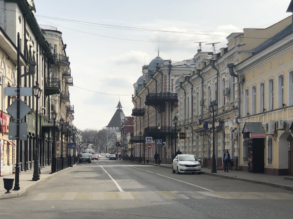 cars parked on side of the road in between buildings during daytime