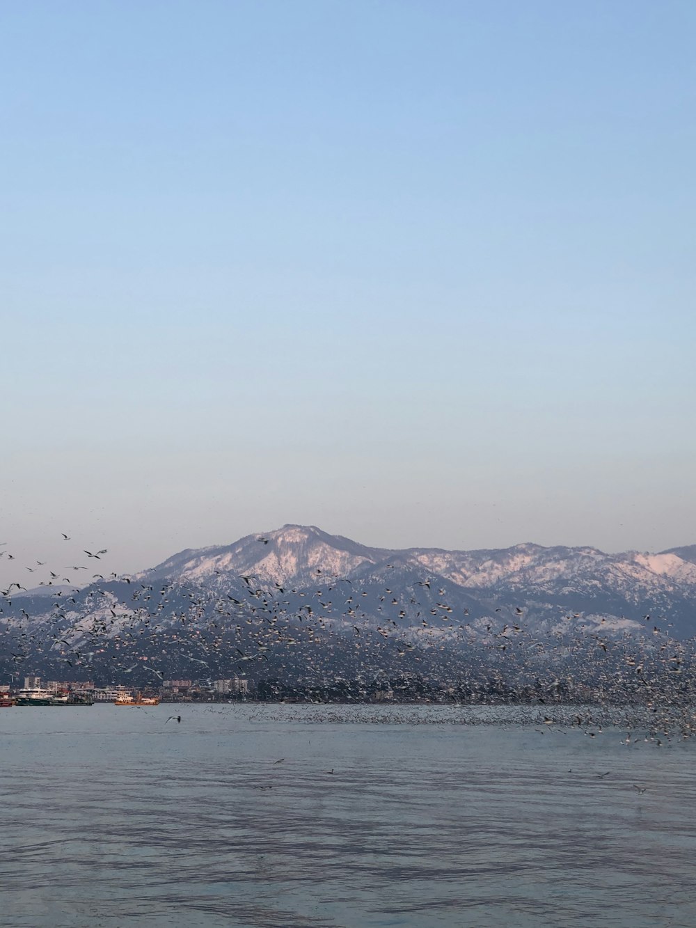 body of water near mountain during daytime