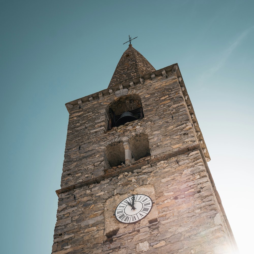 brown brick tower with analog clock