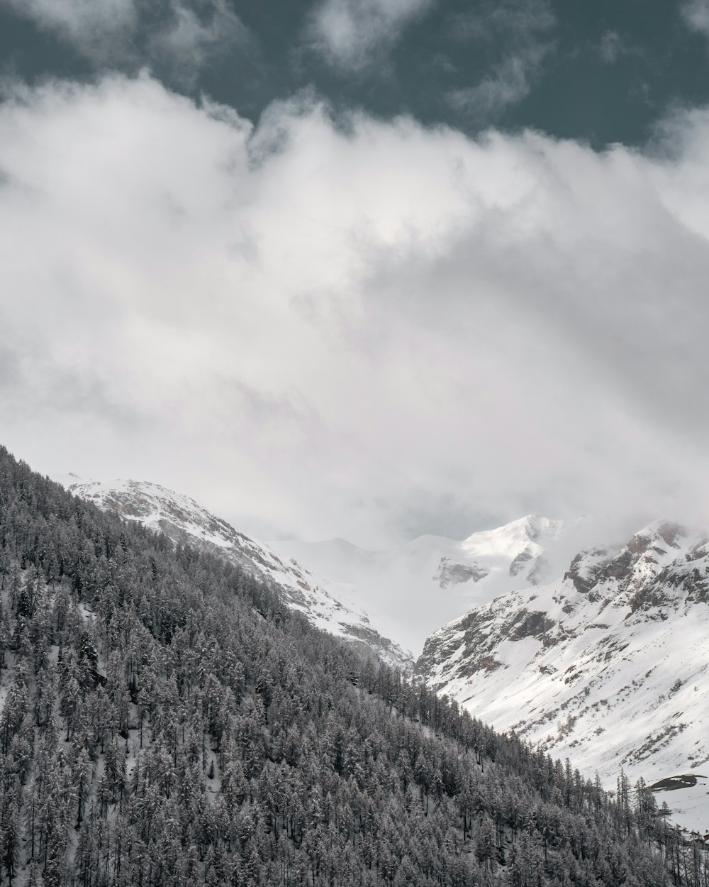 snow covered mountain under cloudy sky during daytime