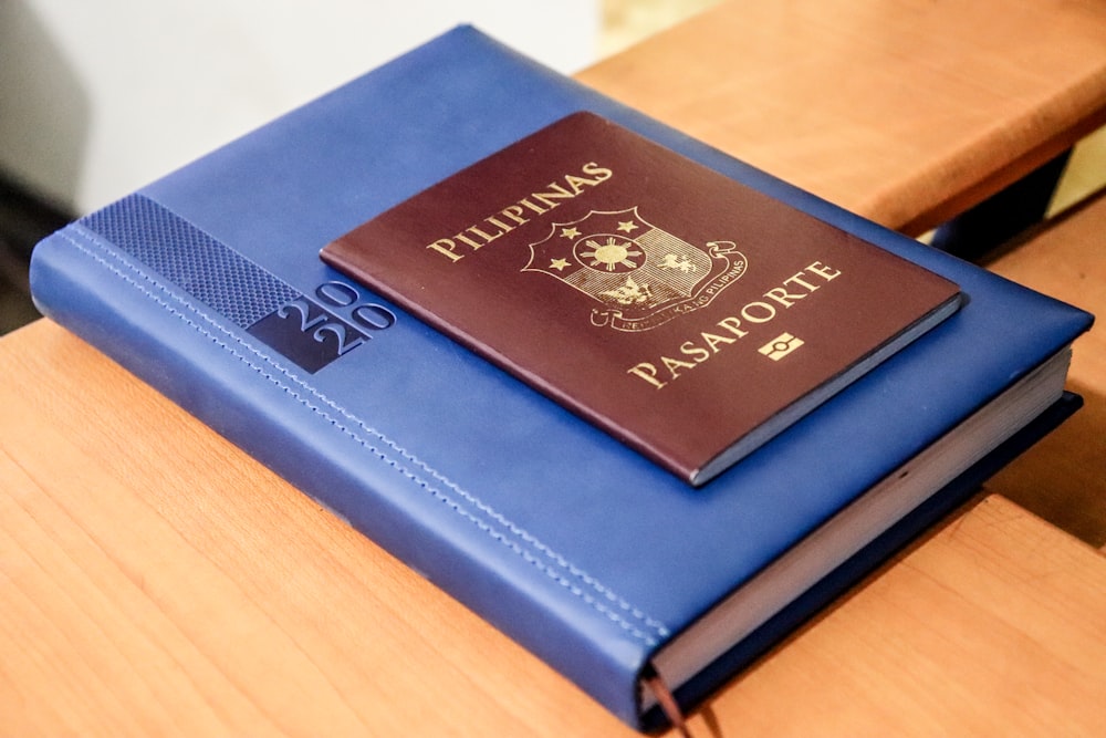 blue and black hardbound book on brown wooden table