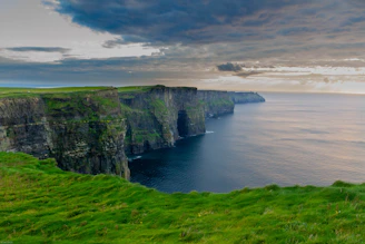 Campo de césped verde junto al mar en los acantilados de Moher en Irlanda