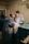 Two medical professionals are performing surgery in an operating room. They are dressed in blue surgical gowns, masks, and hairnets. Surgical instruments and equipment are placed on a table nearby, and the scene is illuminated by focused lighting.