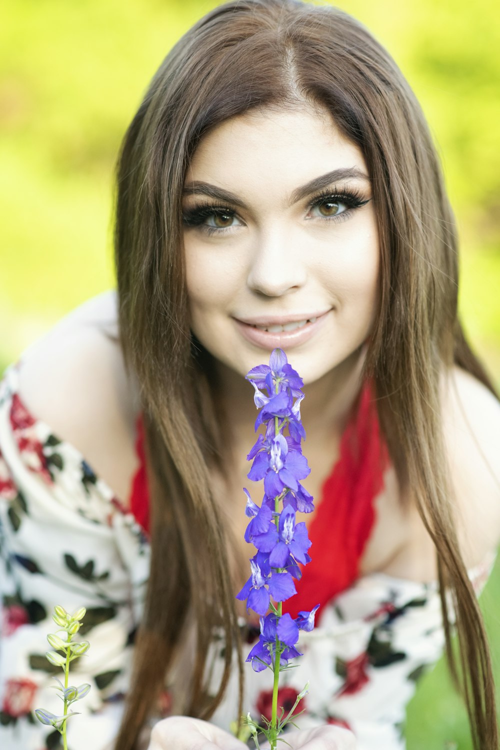 a woman holding a purple flower in her hands