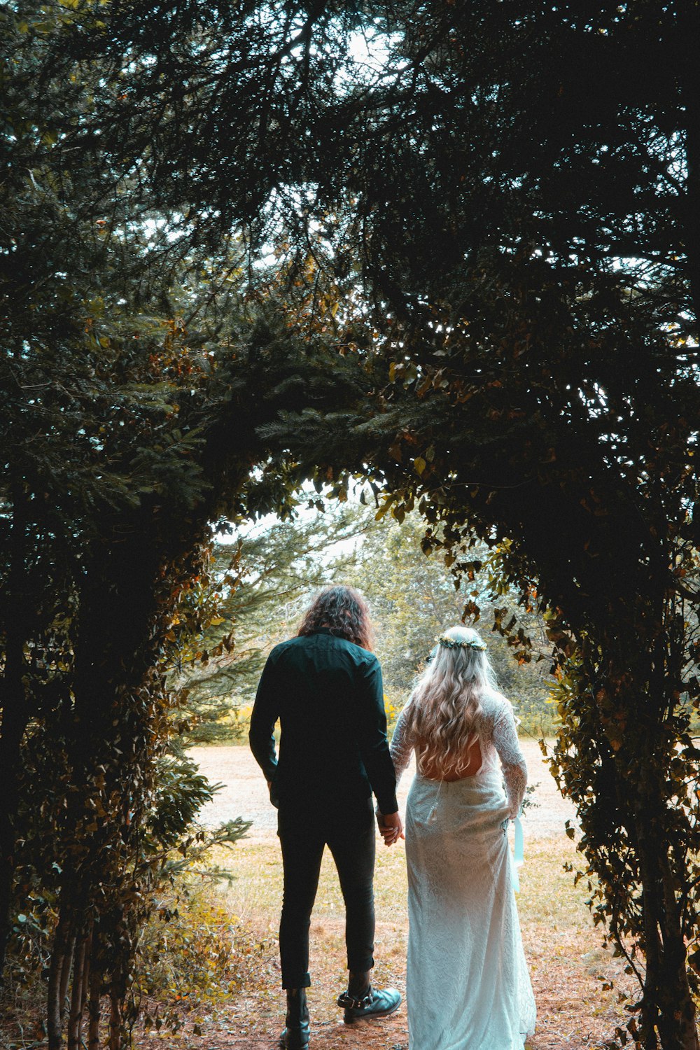 man and woman walking on forest during daytime