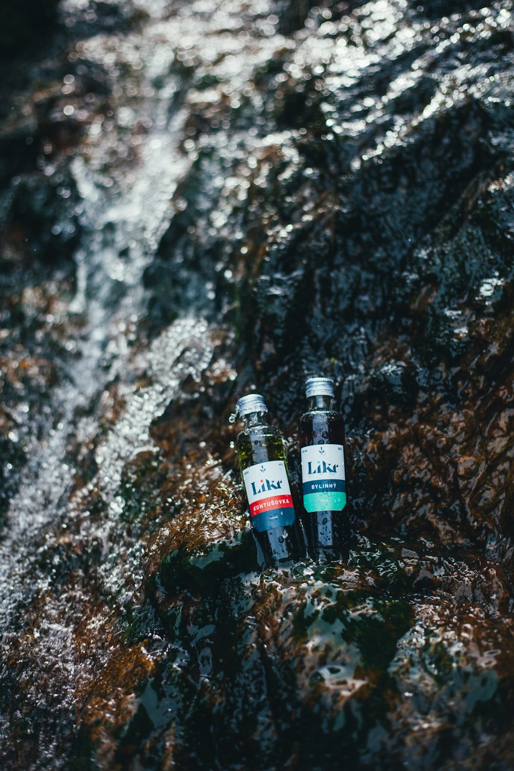 black and white labeled bottle on brown and black rock