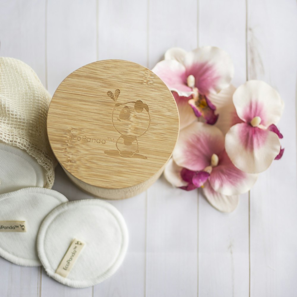 pink and white flowers on brown wooden heart shape board