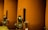 Large, cylindrical vessels with metal fixtures are aligned side by side. The tanks have a matte orange-brown finish, with stainless steel taps and dials attached near the bottom. The setting appears industrial or related to beverage production or storage.