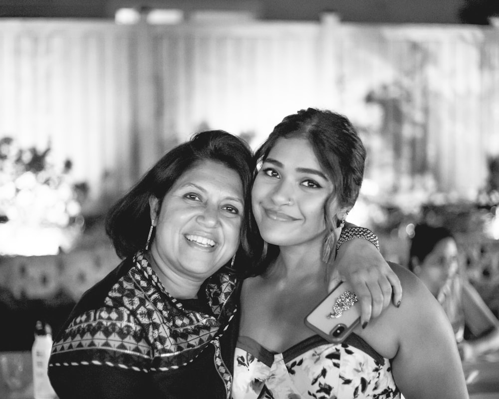 grayscale photo of woman and girl smiling