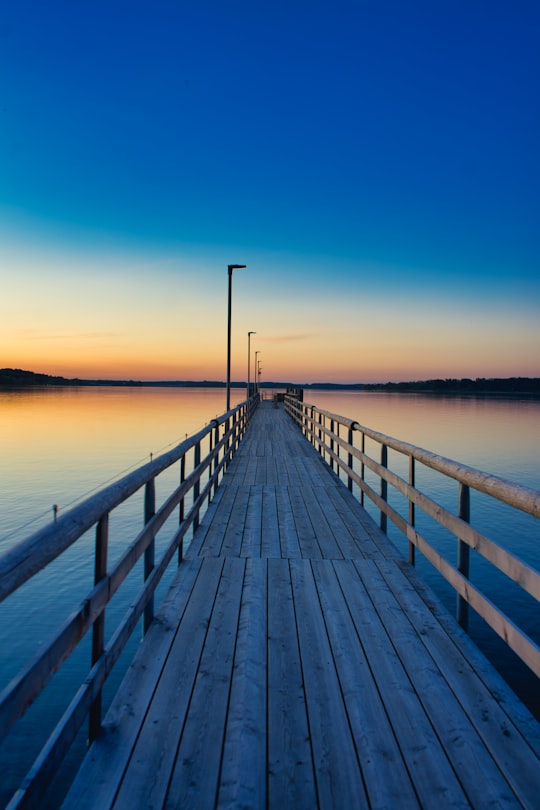 brown wooden dock on sea during sunset in Chiemsee Germany