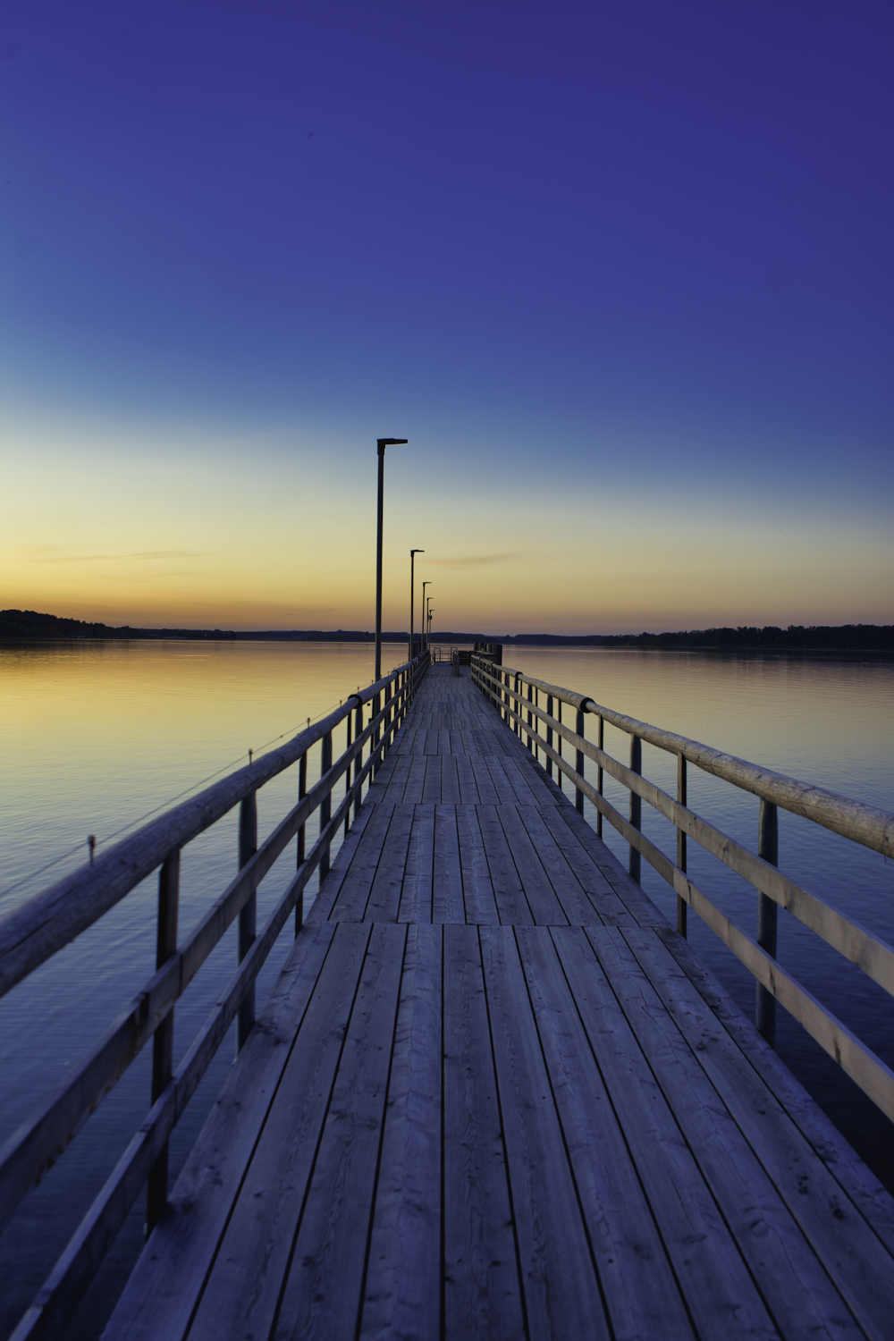 Braunes Holzdock auf See bei Sonnenuntergang