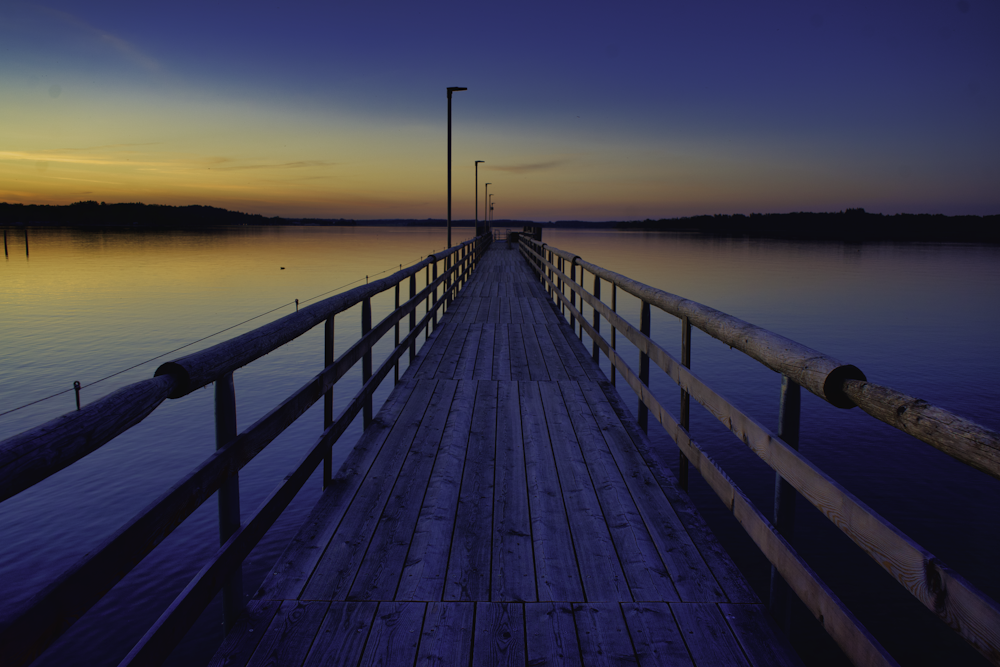 Braunes Holzdock auf See bei Sonnenuntergang