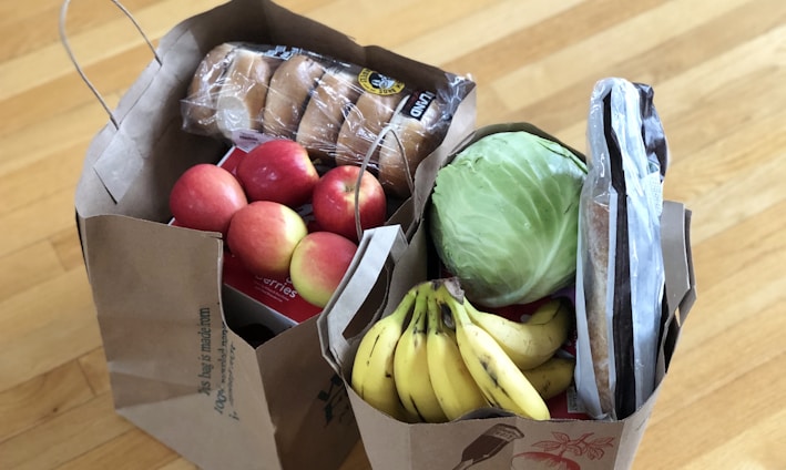 apples and bananas in brown cardboard box