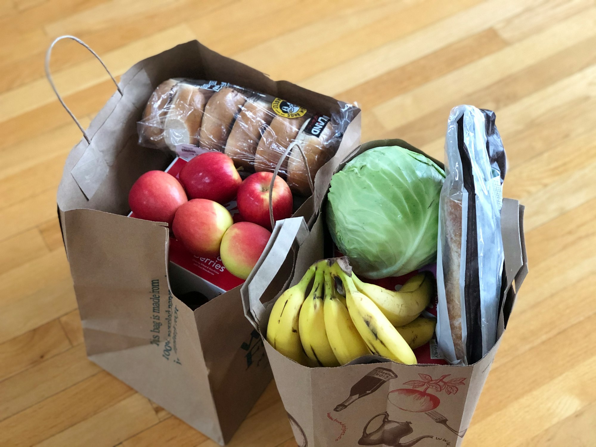 Paper bags with groceries including fruits and vegetables and bread