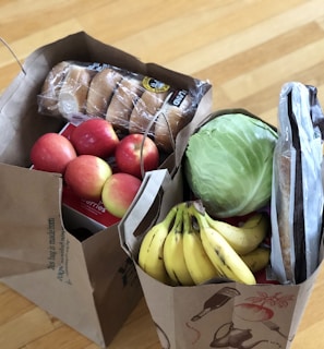 apples and bananas in brown cardboard box