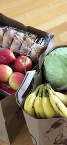 apples and bananas in brown cardboard box