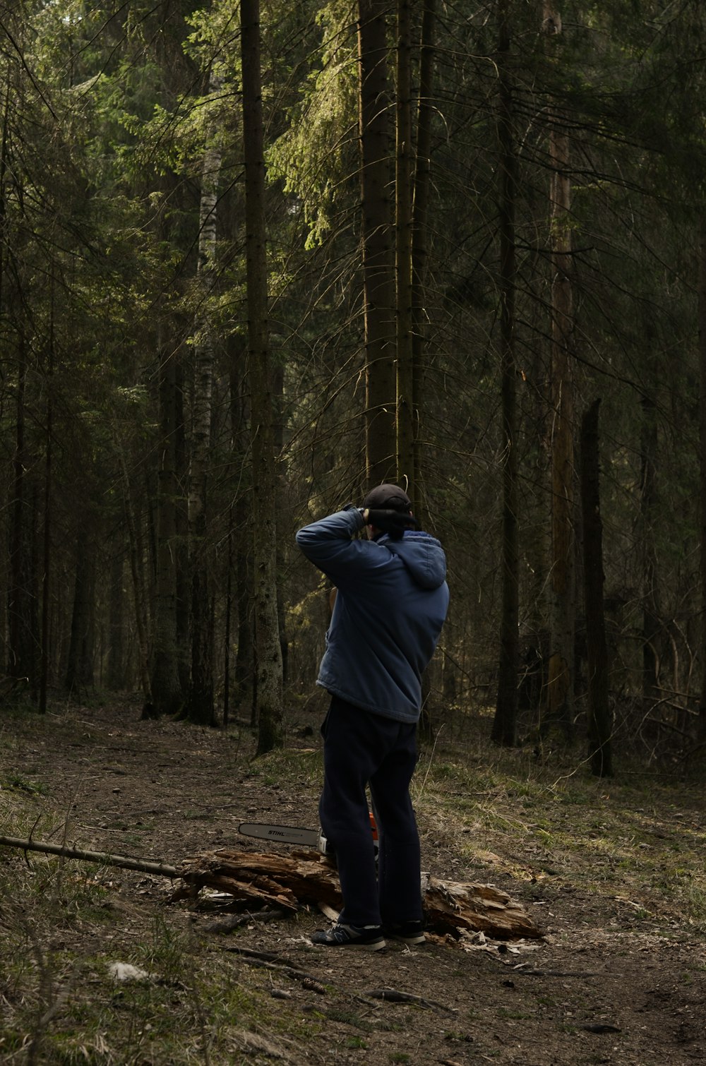 man in gray hoodie standing in the woods