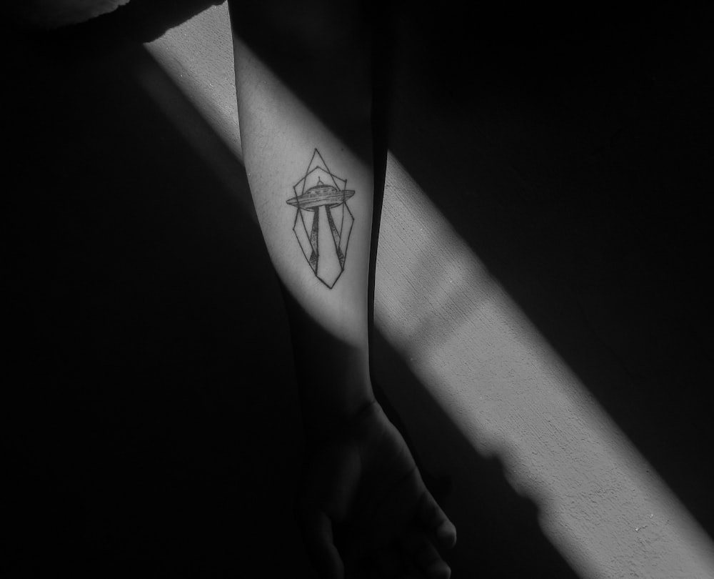 grayscale photo of person with black star tattoo