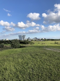 green grass field under blue sky and white clouds during daytime