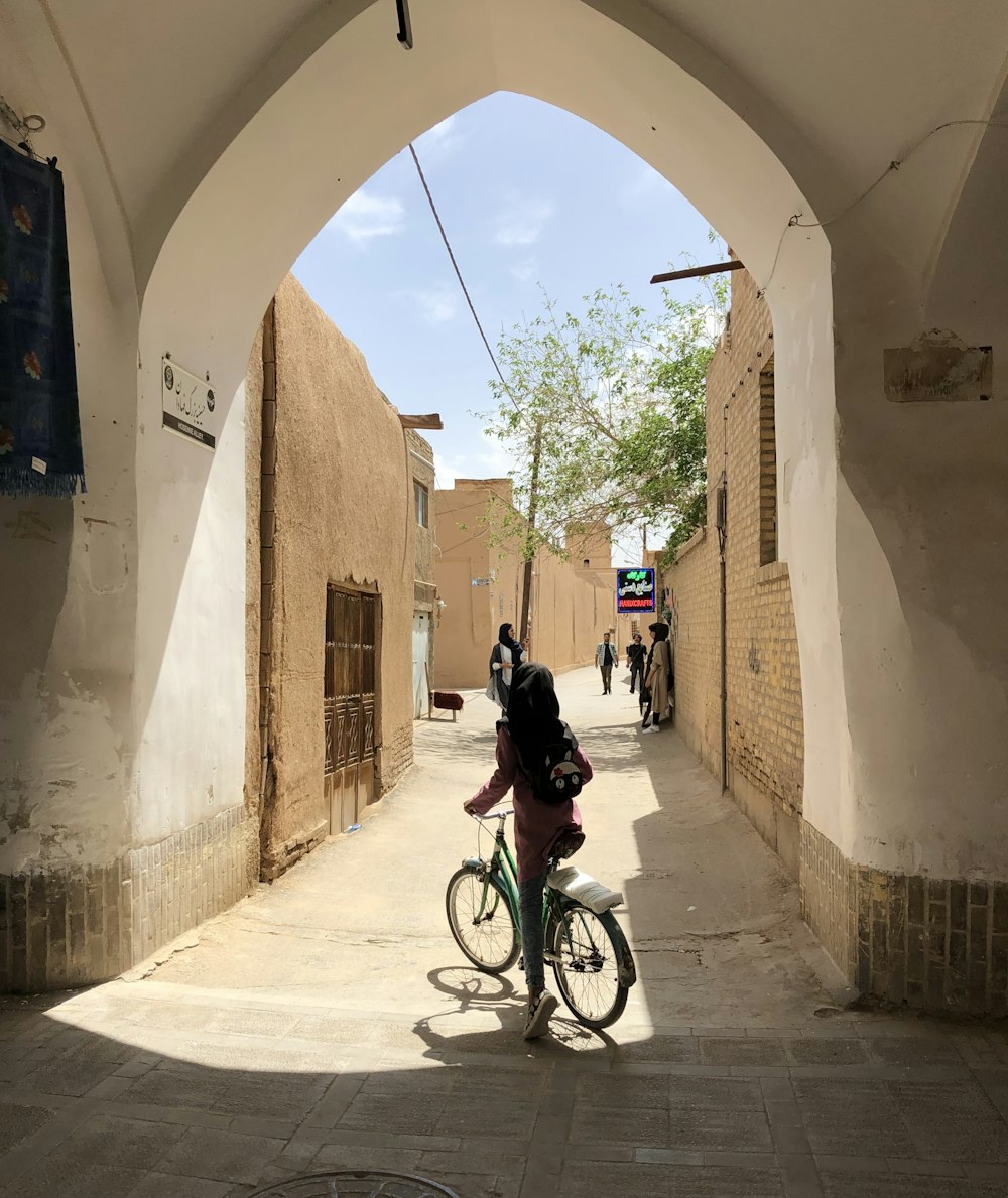 man in black jacket riding bicycle on gray concrete road during daytime