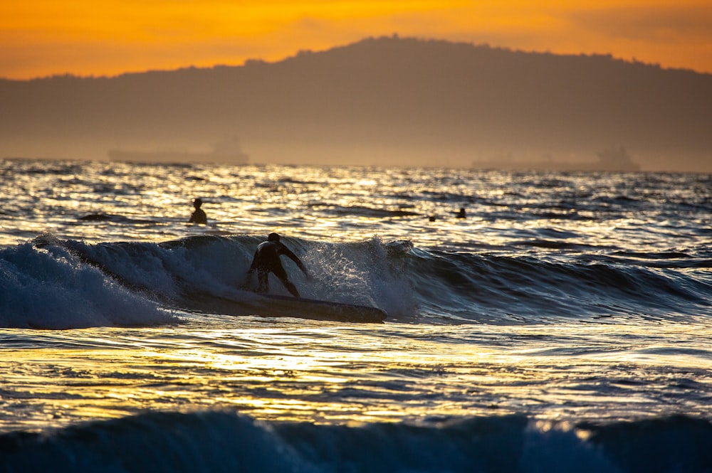 person surfing on sea waves during sunset