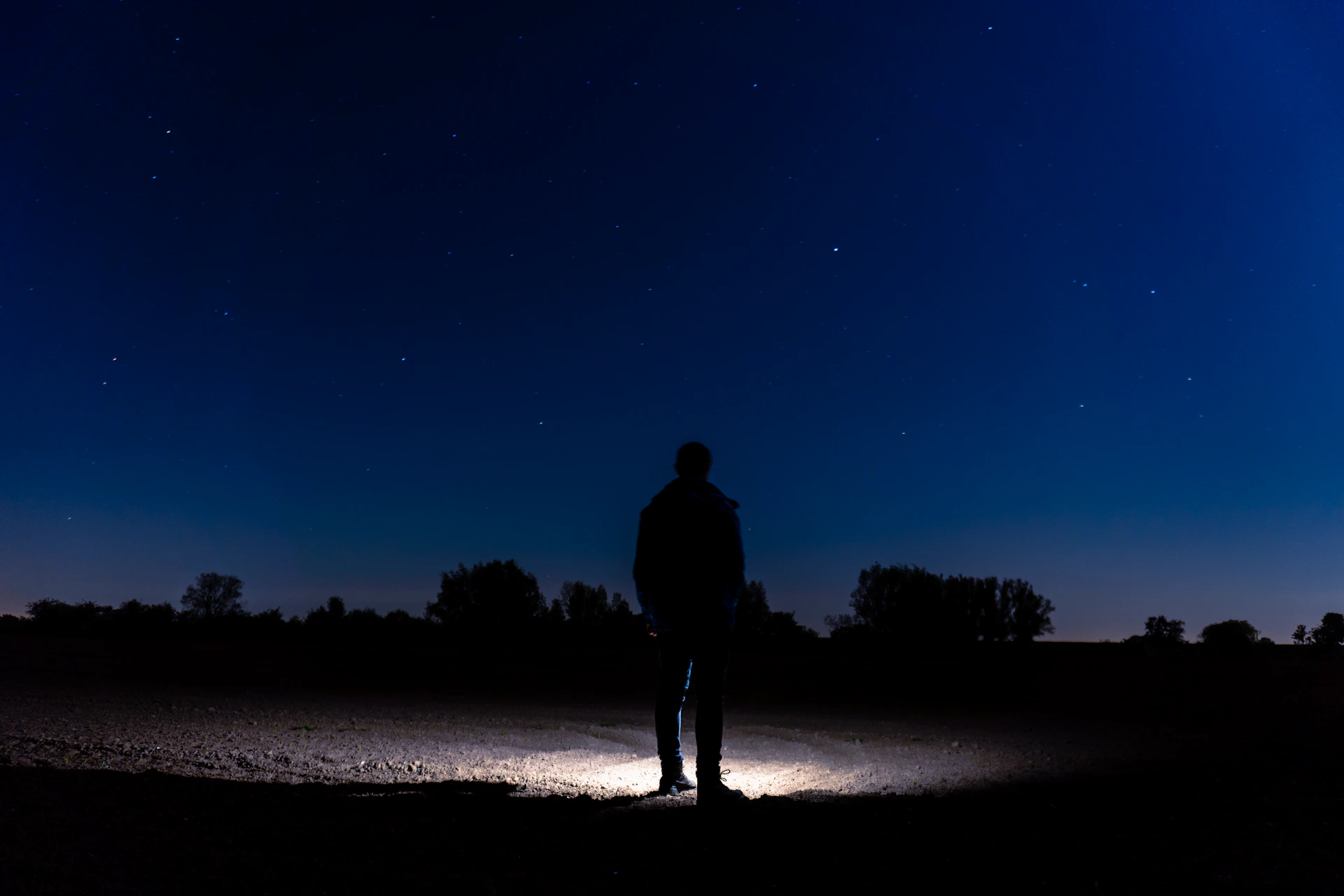 silhouette of man standing on beach during night time