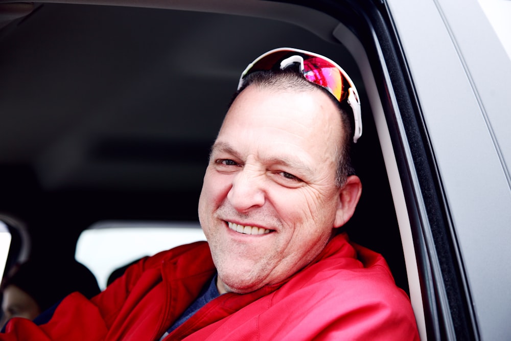 man in red dress shirt wearing black sunglasses