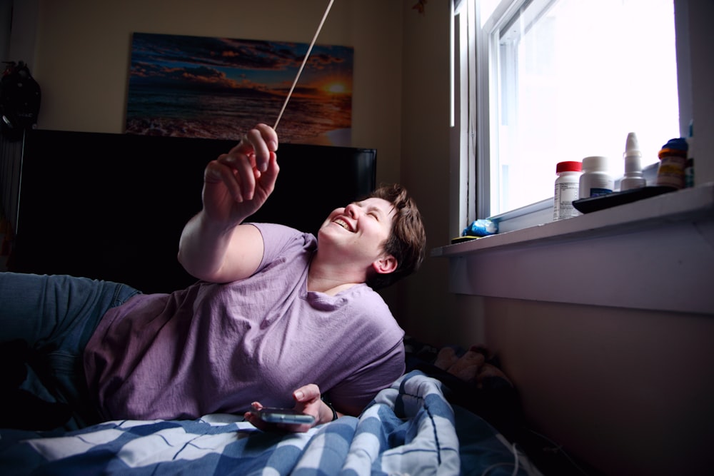 woman in purple crew neck t-shirt lying on bed