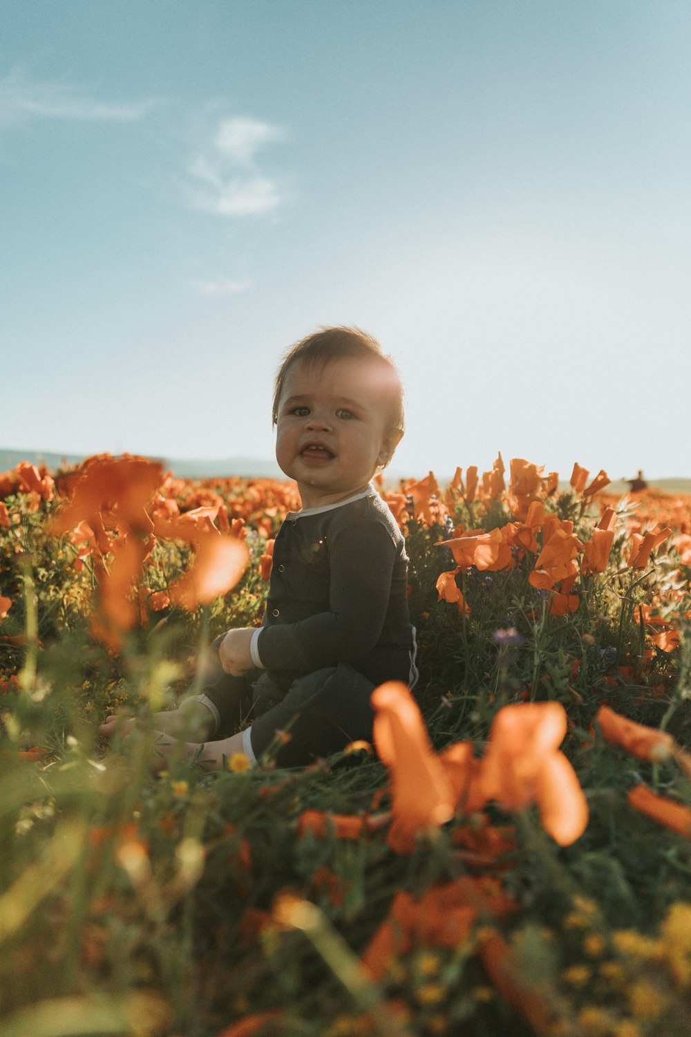 boy in black suit sitting on brown flower field during daytime
