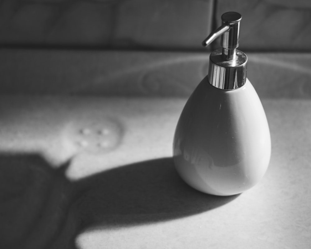 white and black pump bottle on sink