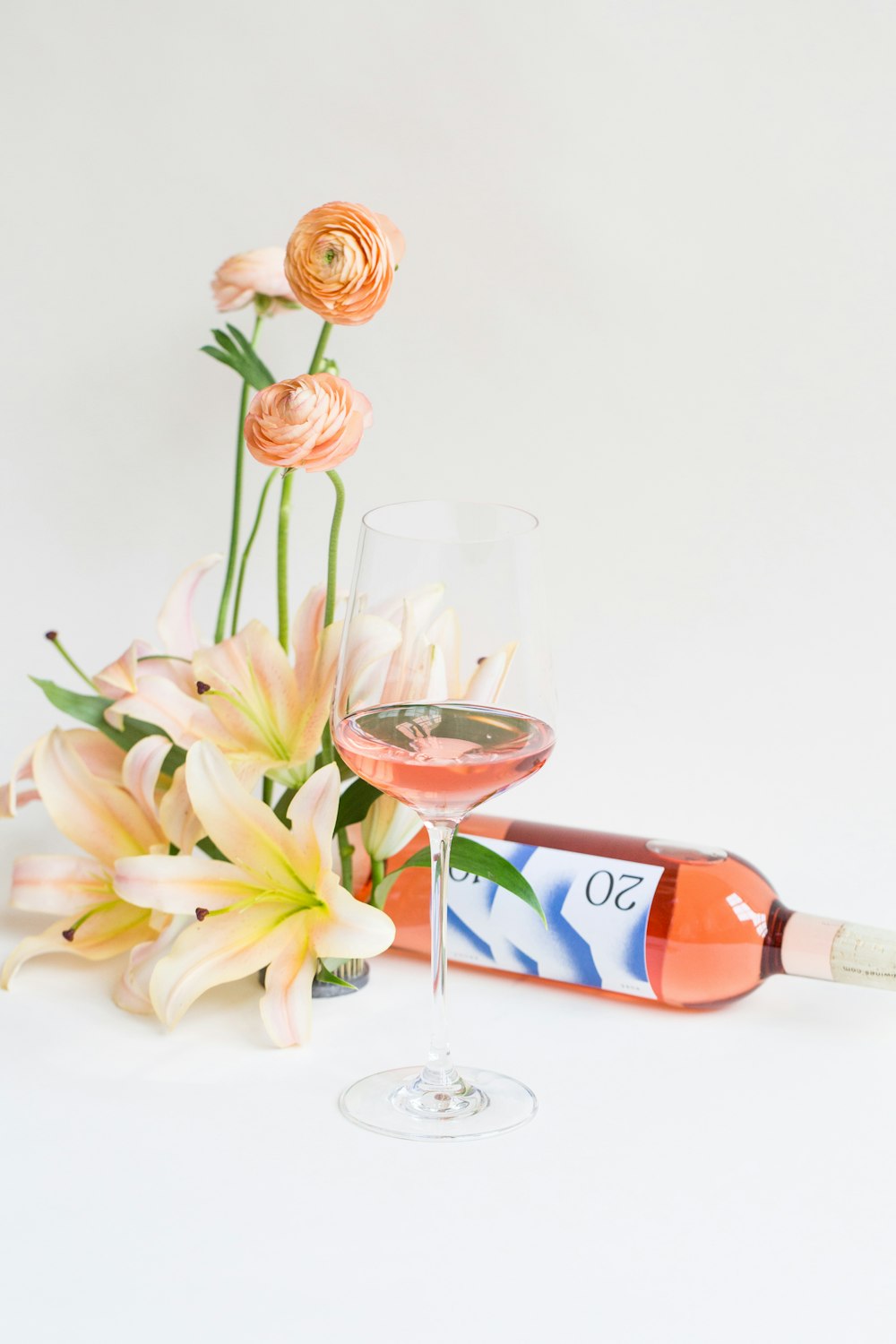 와인 병과 와인 잔 옆에 흰 꽃