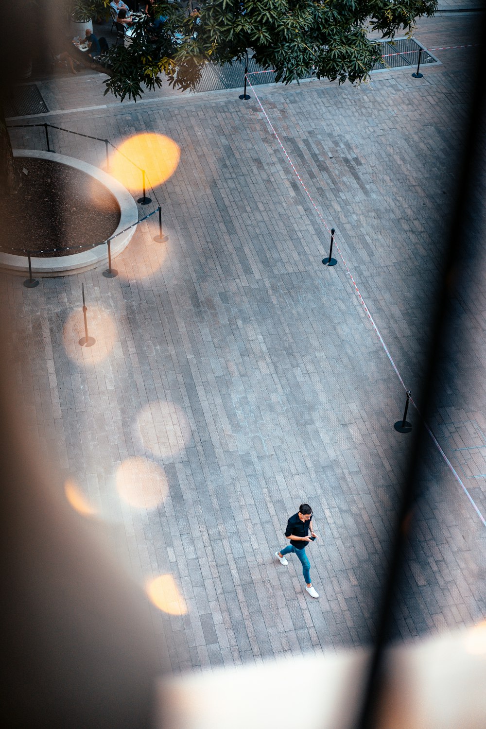 man in black t-shirt and blue denim jeans walking on gray concrete floor