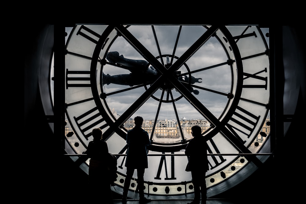 man and woman standing in front of black and white round analog wall clock