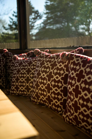 A cozy window bench adorned with soft linen pillow shams in calming neutral tones.