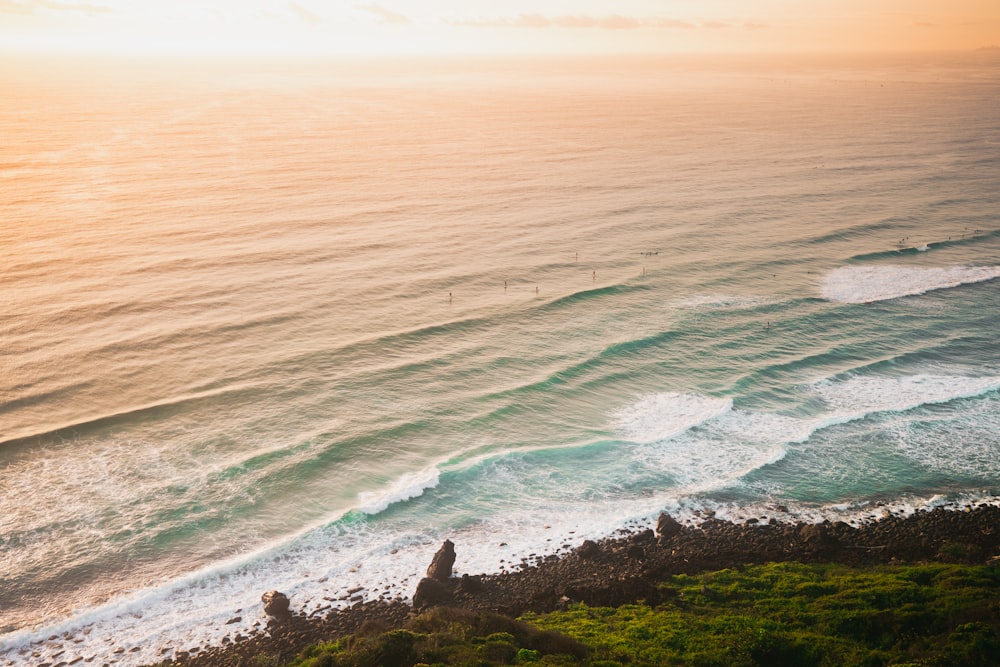 aerial view of ocean waves crashing on shore during daytime