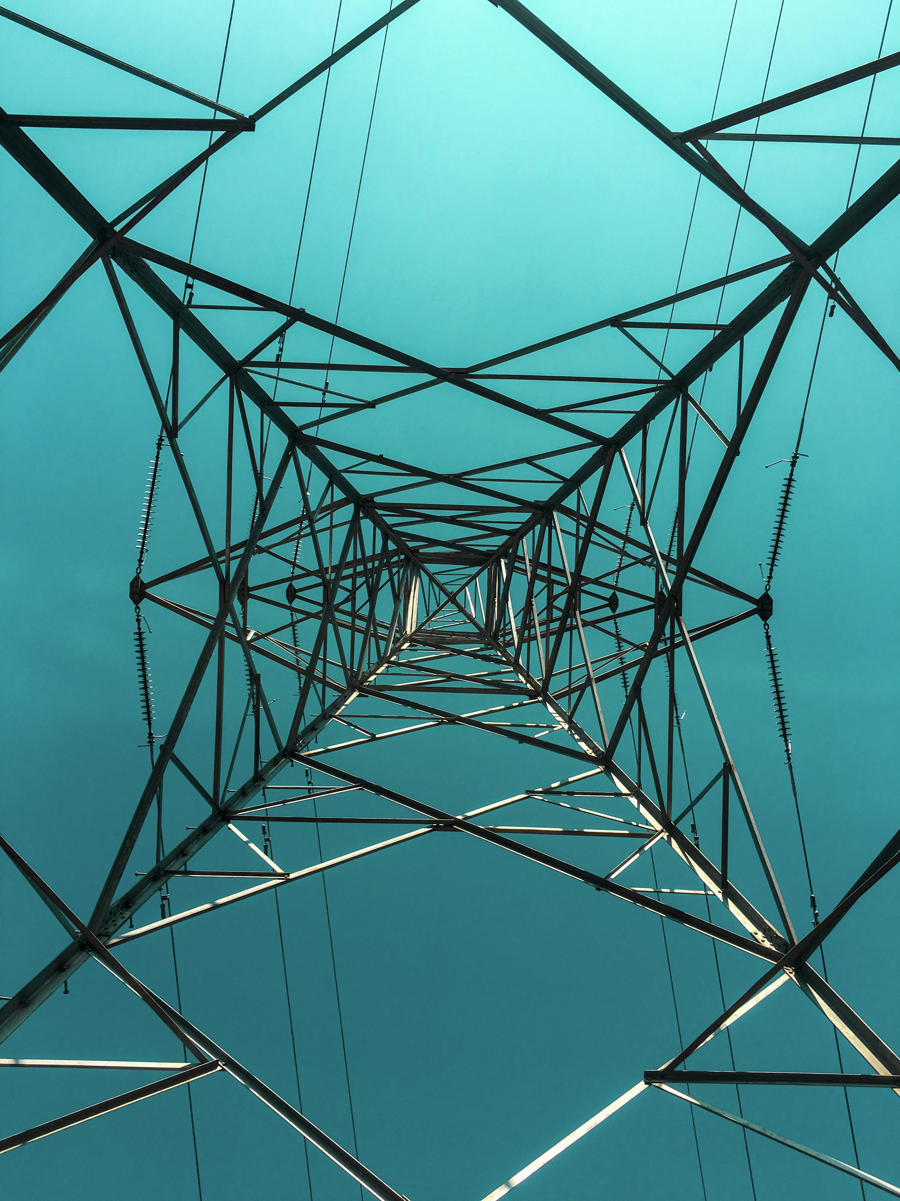 black metal electric tower under blue sky during daytime