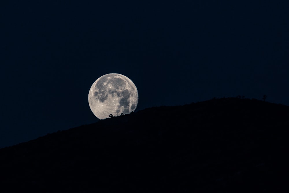 silhouette of mountain under full moon