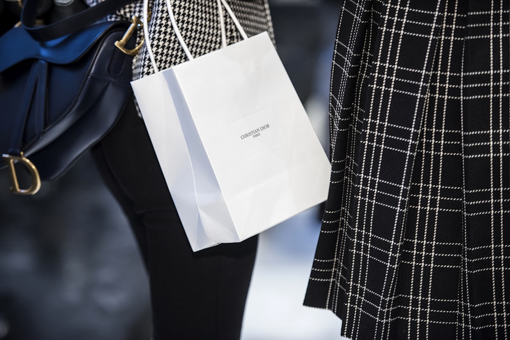 Bolsa de papel blanco sobre textil azul y blanco