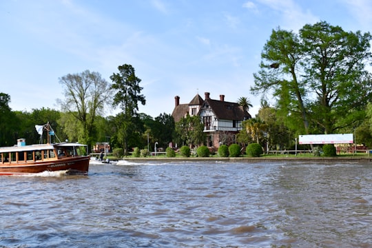 brown boat on body of water near brown and white house during daytime in Tigre Argentina