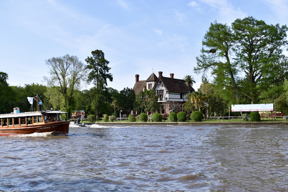 brown boat on body of water near brown and white house during daytime