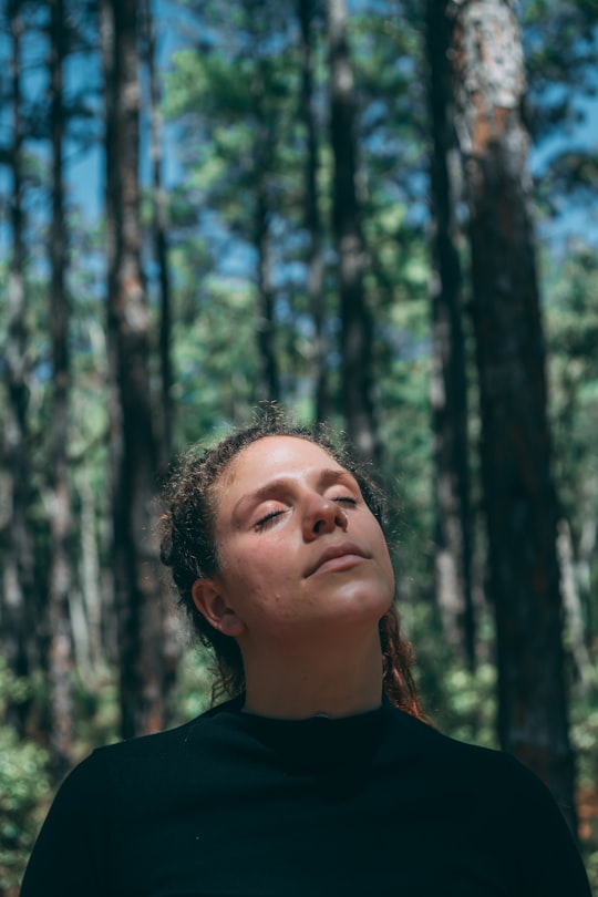 woman in black crew neck shirt standing near trees during daytime in Florianópolis Brasil
