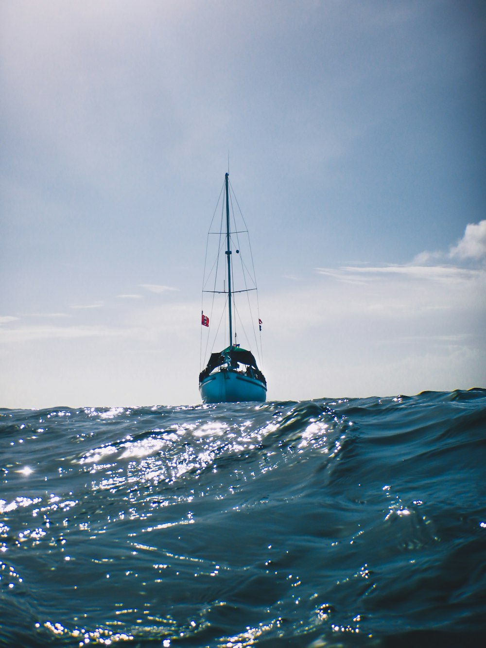 blue and white sail boat on body of water