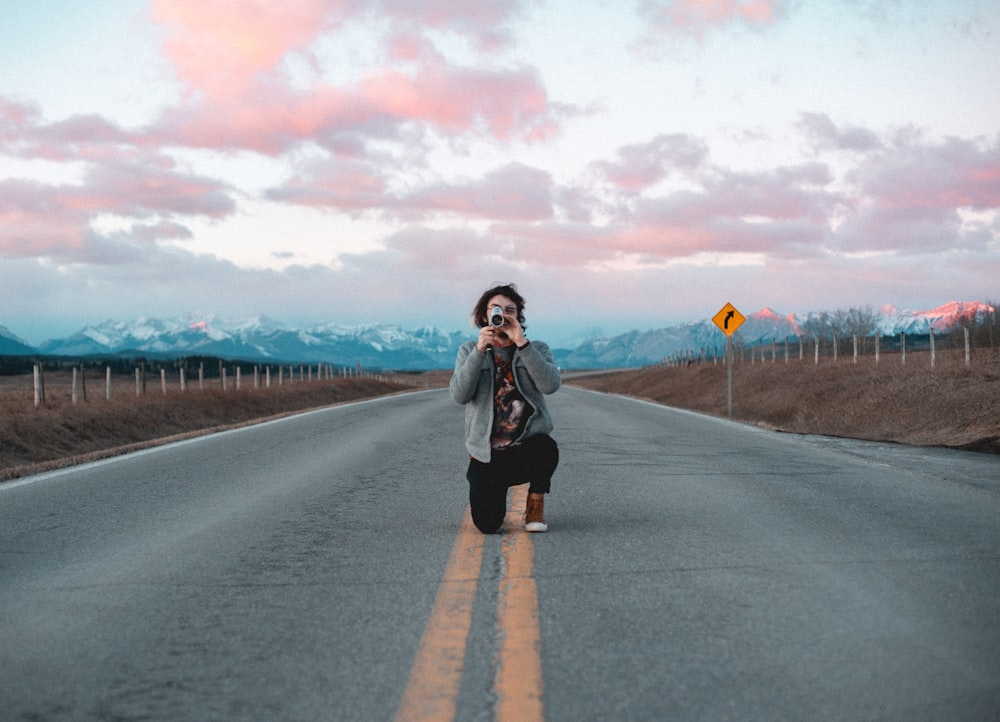 woman in black jacket standing on road during daytime
