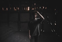man in black t-shirt standing on street during nighttime