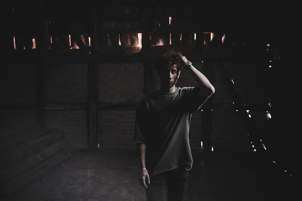 검은 티셔츠를 입은 남자가 밤에 거리에 서 있다
