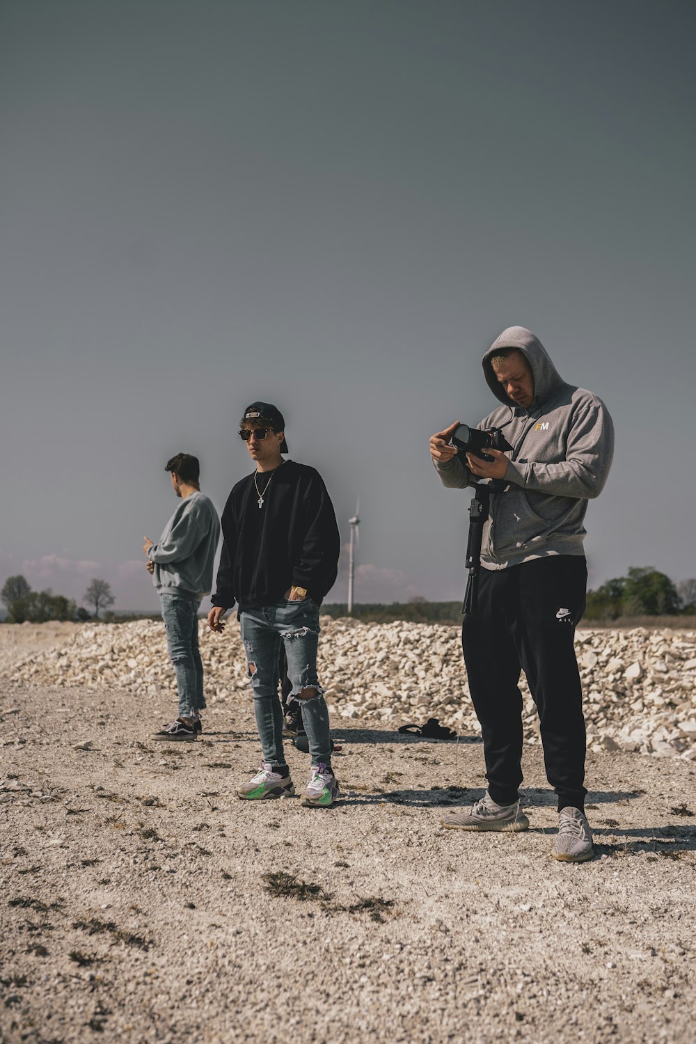 Hombre con chaqueta negra y jeans de mezclilla azul sosteniendo una cámara DSLR negra