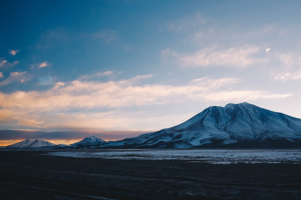 snow covered mountain under cloudy sky during daytime