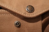 Close-up of detailed stitching and buttons on a custom-made jacket.